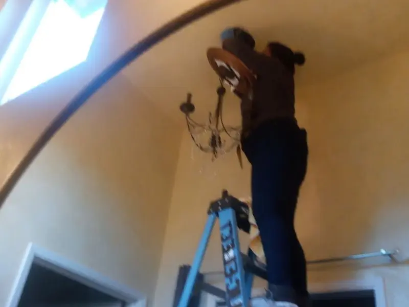 Electrician installing a chandelier in a East Basin residence
